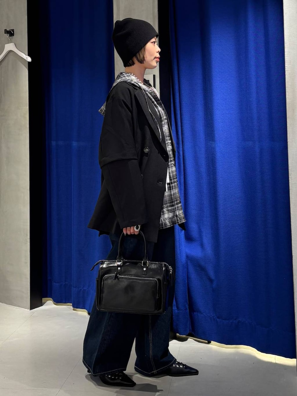 ブルー系のスラックス、ブラック系のショルダーバッグ、ブラック系のサンダルを着用したレディースの春コーディネートの4枚目の写真