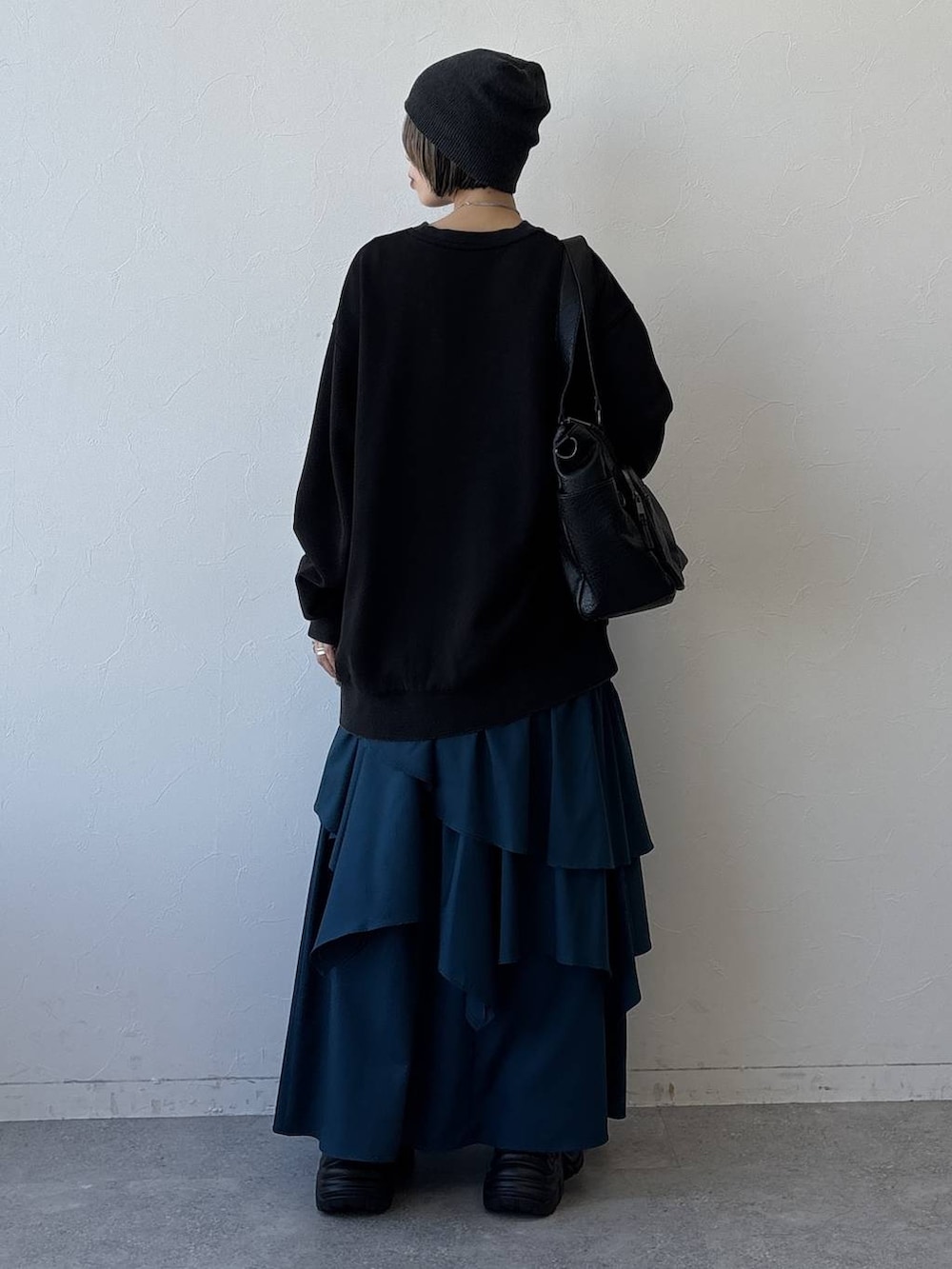 グレー系のスニーカー、ブラック系のボストンバッグ、ブルー系のスカートを着用したレディースの冬コーディネートの6枚目の写真