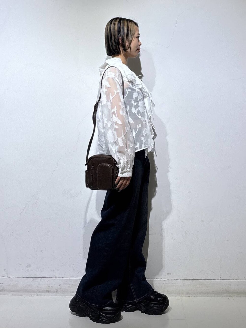 ブラック系のスニーカー、ブラック系のキャミソール、ブルー系のスラックスを着用したレディースの春コーディネートの4枚目の写真