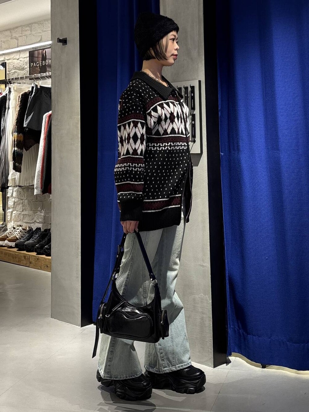 ブラック系のブーツ、ブルー系のデニムパンツ、ブラック系のショルダーバッグを着用したレディースの冬コーディネートの3枚目の写真