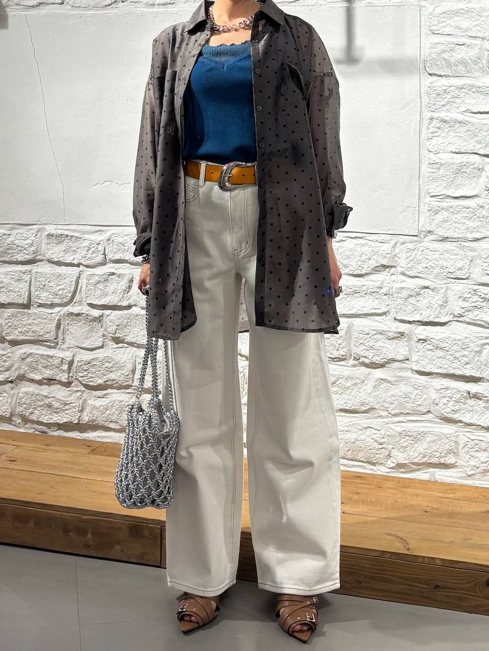 ホワイト系のデニムパンツ、シルバー系のショルダーバッグ、イエロー系のサンダルを着用したレディースの春コーディネートの3枚目の写真