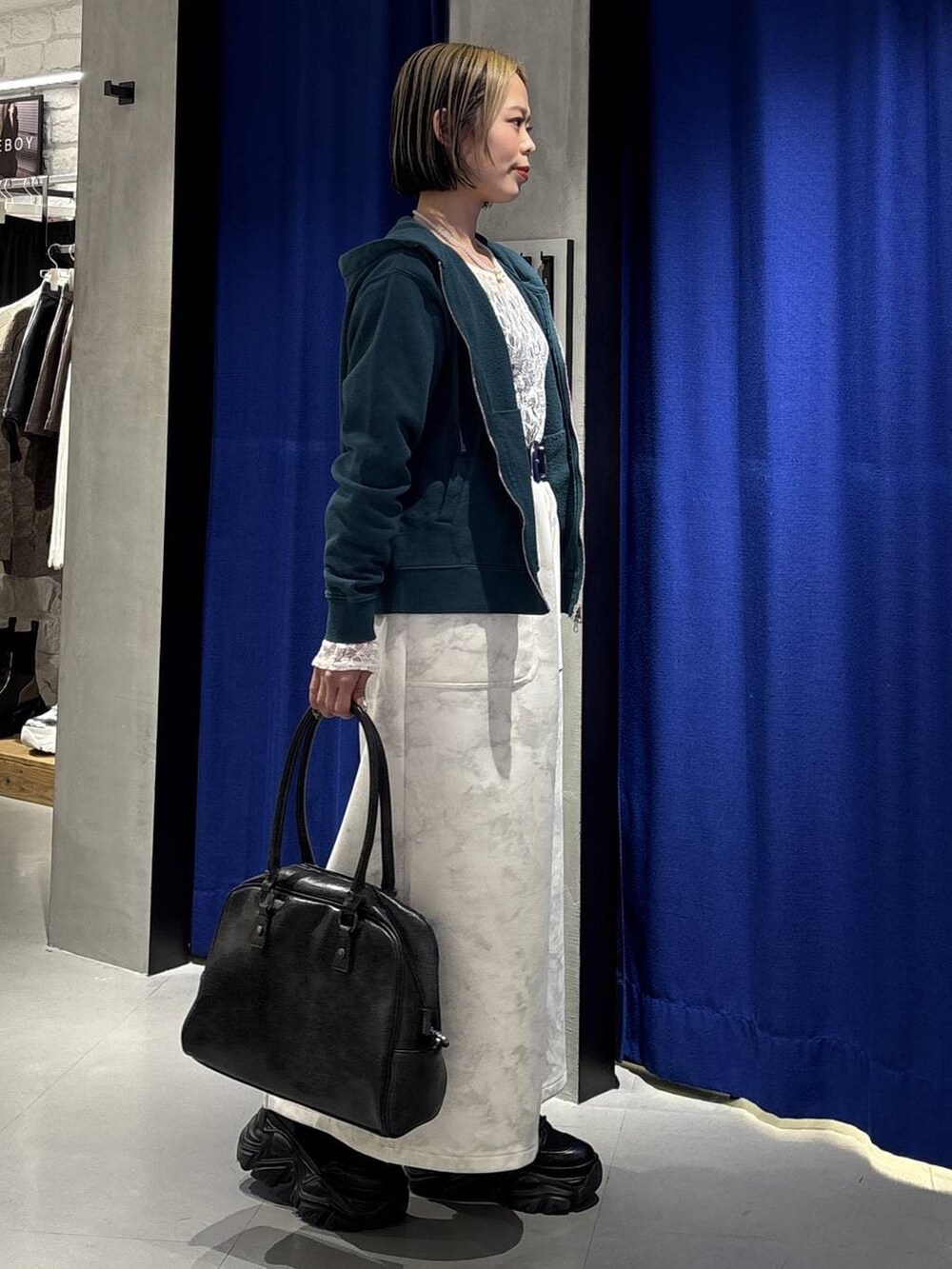 ブラック系のブーツ、ブラック系のボストンバッグ、ホワイト系のTシャツ/カットソーを着用したレディースの冬コーディネートの5枚目の写真