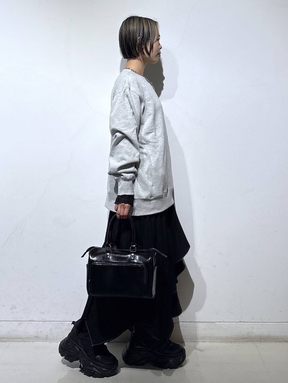 ブラック系のスニーカー、グレー系のスウェット、ブラック系のスカートを着用したレディースの春コーディネートの3枚目の写真