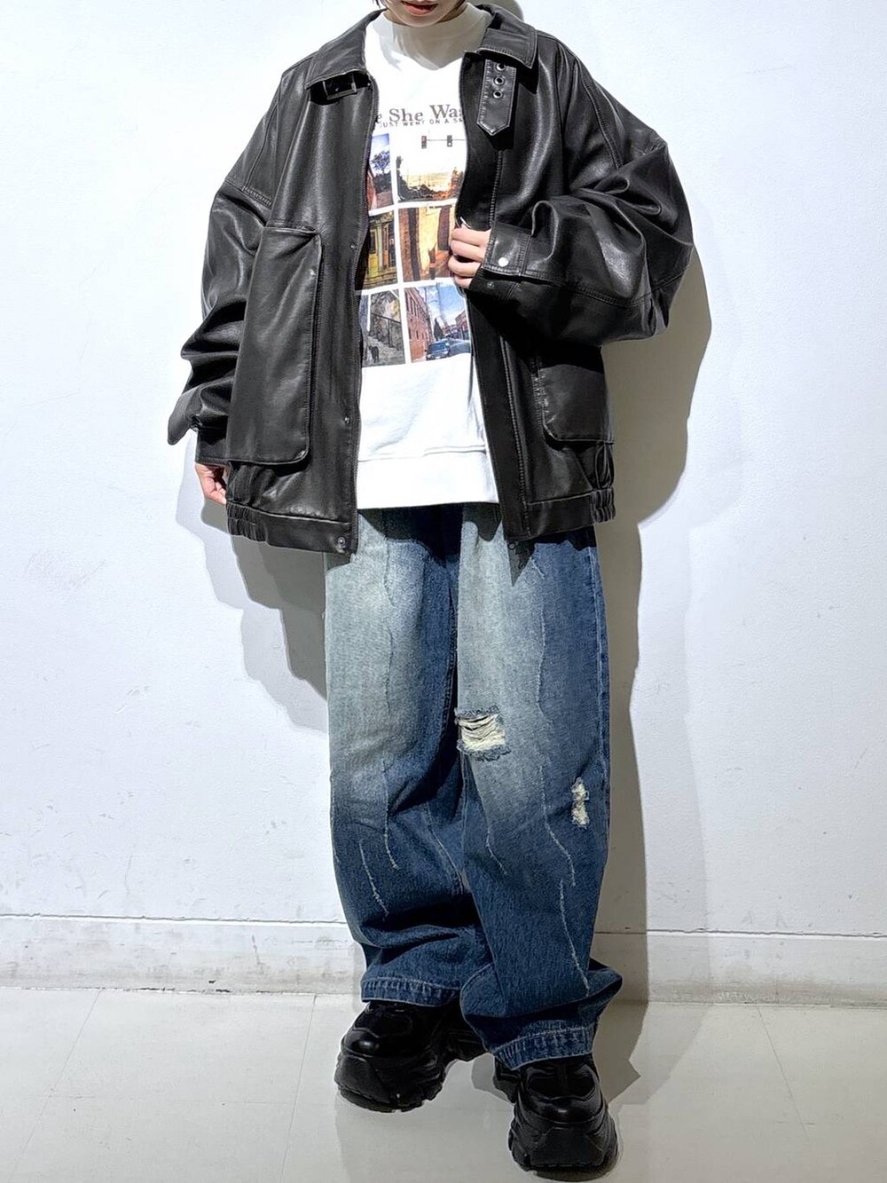 ブラック系のブーツ、ブルー系のデニムパンツ、ブラック系のブルゾンを着用したレディースの秋コーディネートの2枚目の写真