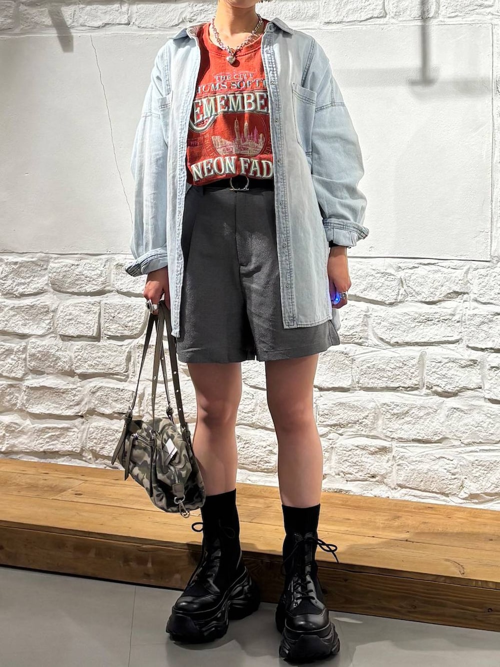 ブラック系のブーツ、ブルー系のシャツ/ブラウス、レッド系のTシャツ/カットソーを着用したレディースの春コーディネートの3枚目の写真
