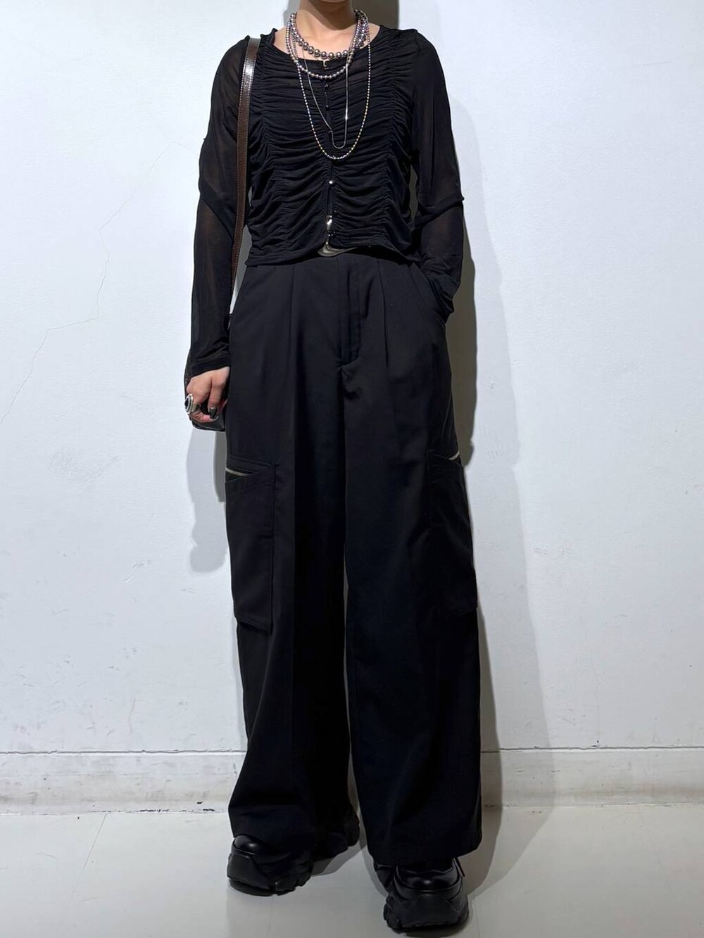 ブラック系のスニーカー、ブラック系のキャミソール、ブラック系のスラックスを着用したレディースの春コーディネートの2枚目の写真