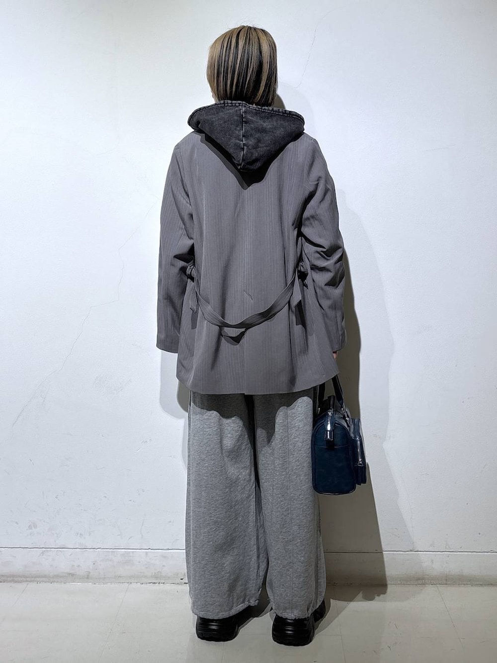 ブラック系のスニーカー、グレー系のテーラードジャケット、グレー系のパーカーを着用したレディースの冬コーディネートの5枚目の写真