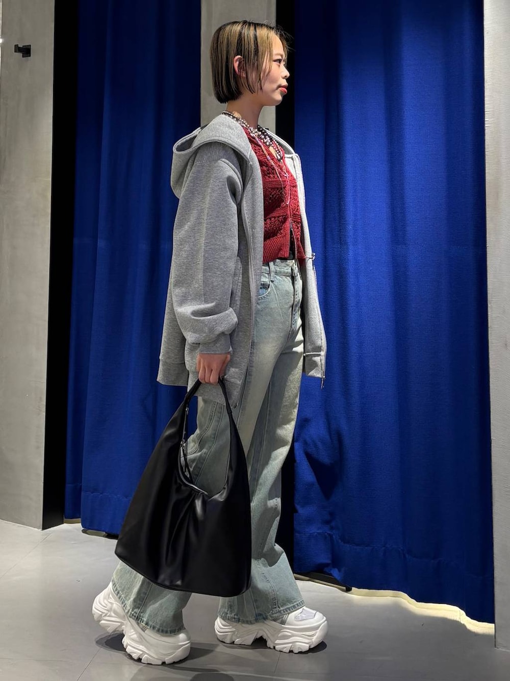 ホワイト系のスニーカー、ブラック系のキャミソール、ブルー系のデニムパンツを着用したレディースの春コーディネートの3枚目の写真