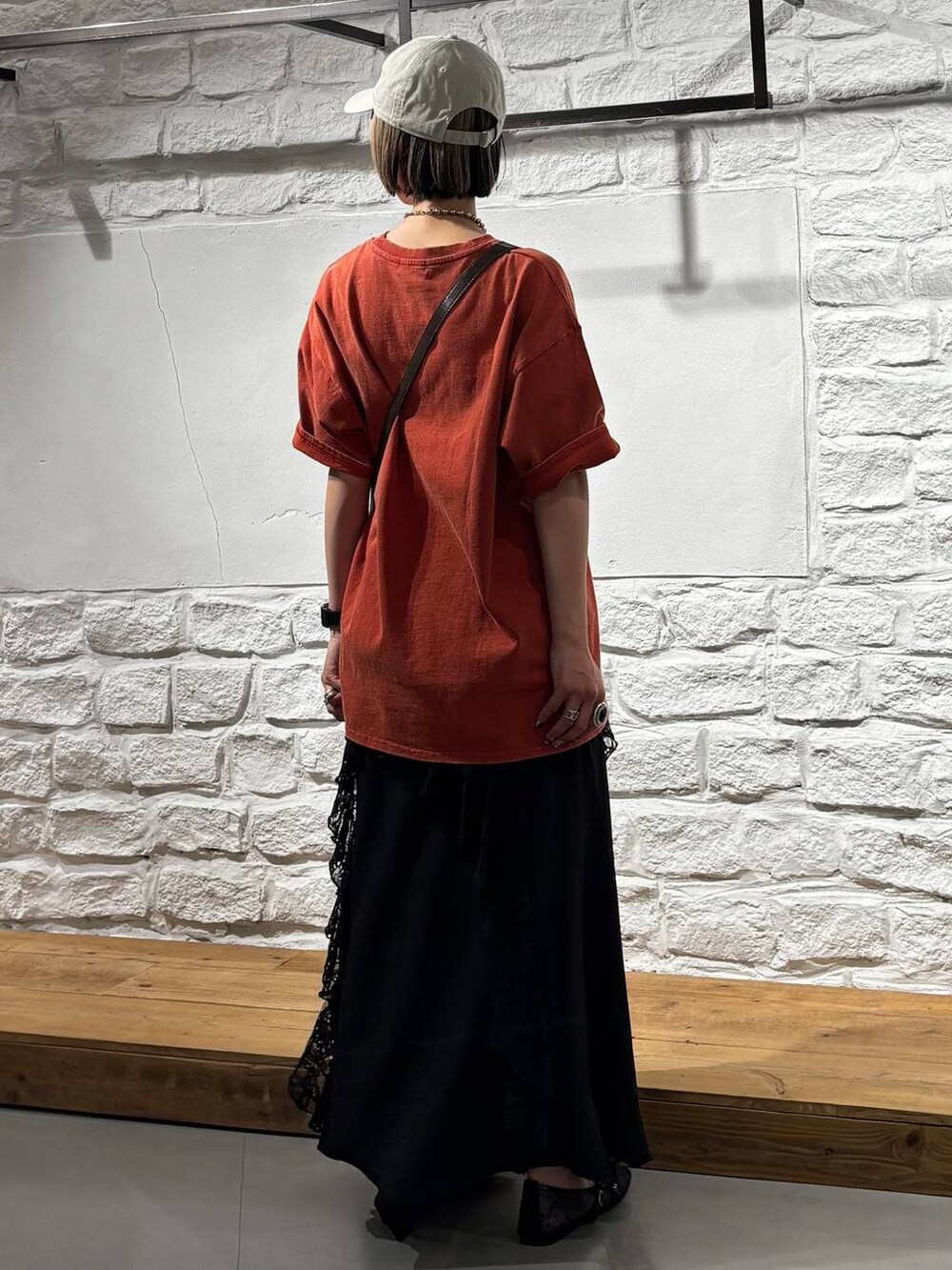 ブラウン系のショルダーバッグ、ブラック系のパンプス、レッド系のTシャツ/カットソーを着用したレディースの春コーディネートの5枚目の写真
