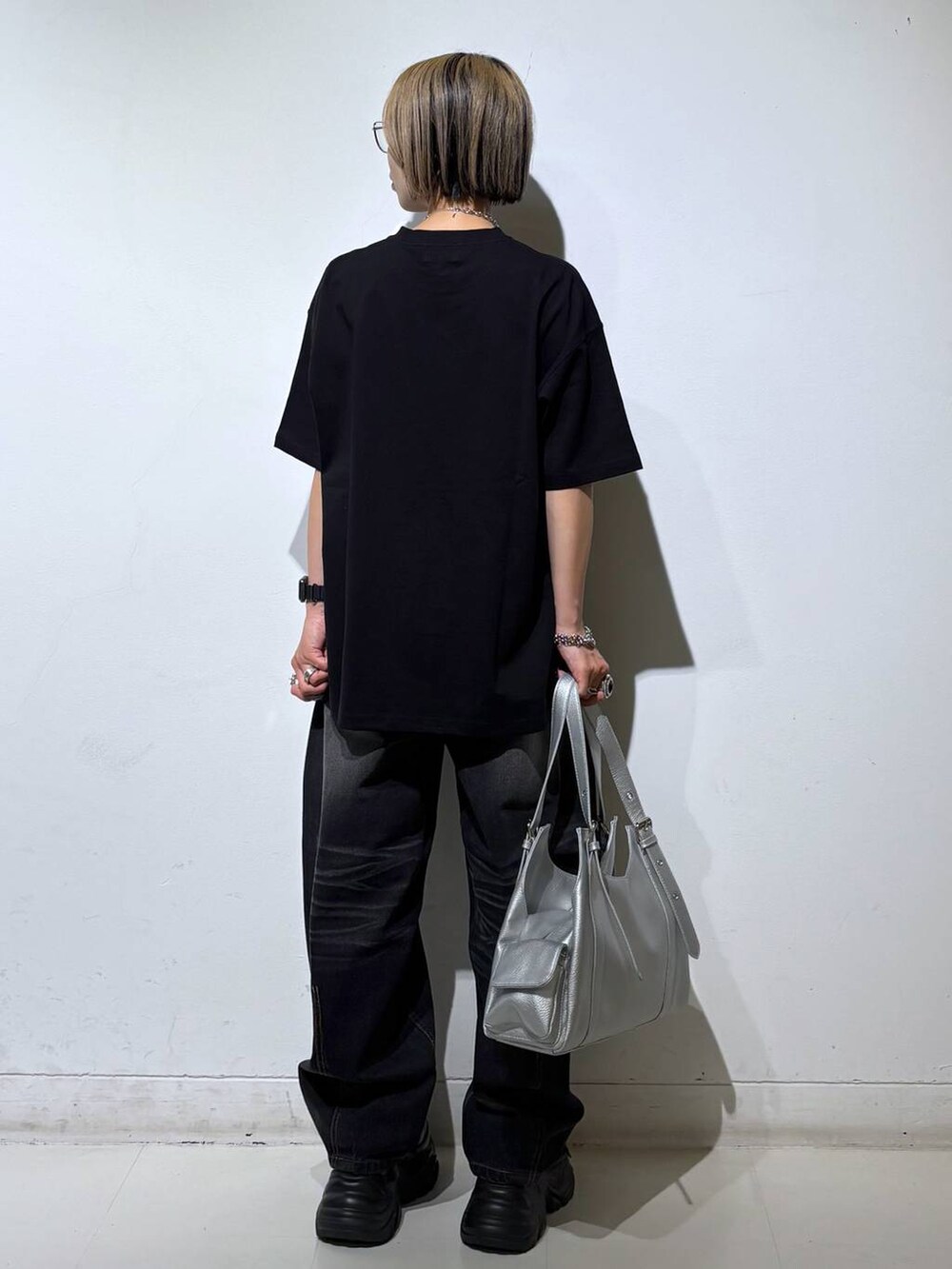 ブラック系のスニーカー、シルバー系のハンドバッグ、ブラック系のTシャツ/カットソーを着用したレディースの夏コーディネートの5枚目の写真