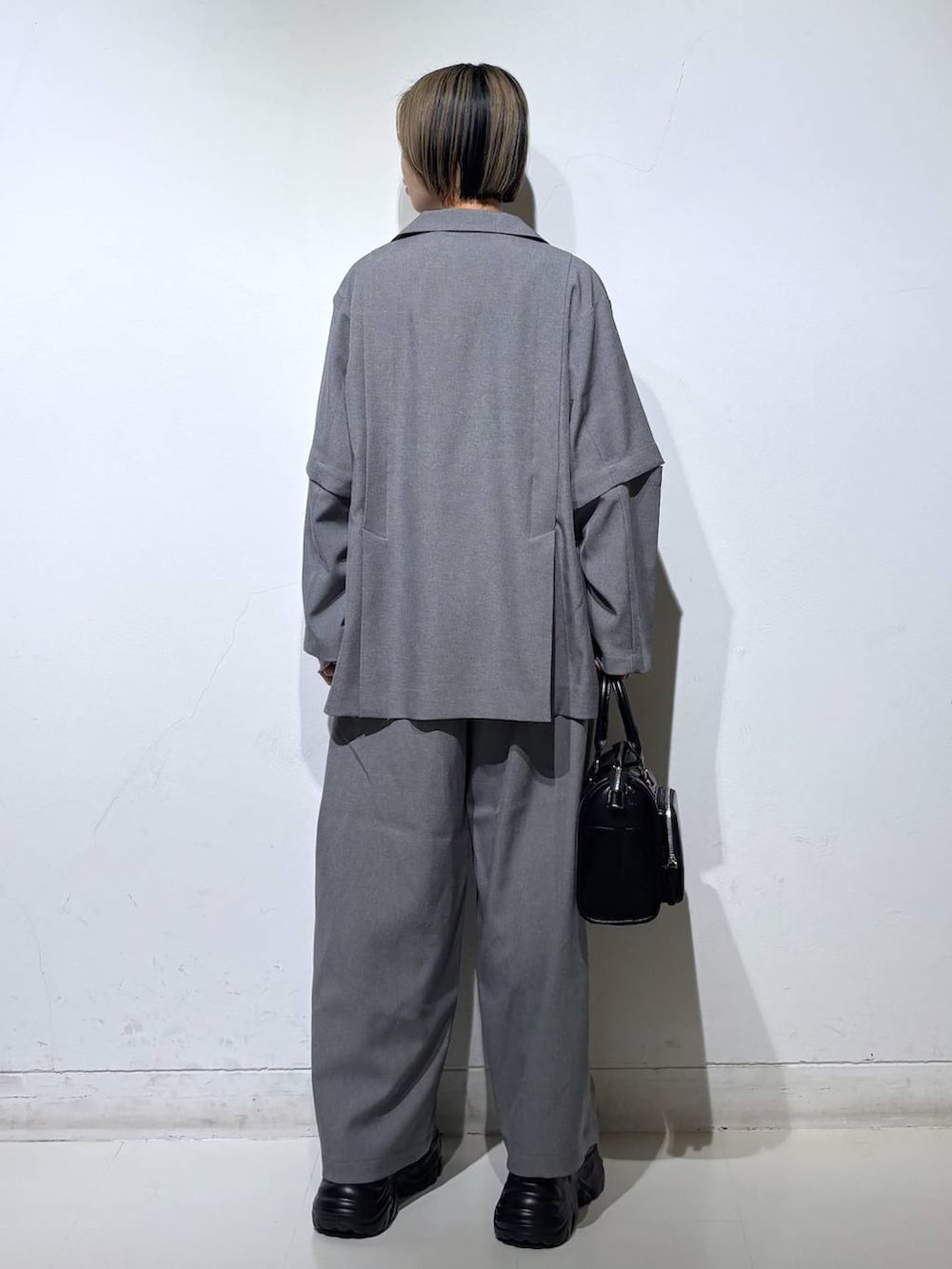 ブラック系のスニーカー、ブラック系のショルダーバッグ、ホワイト系のTシャツ/カットソーを着用したレディースの春コーディネートの4枚目の写真