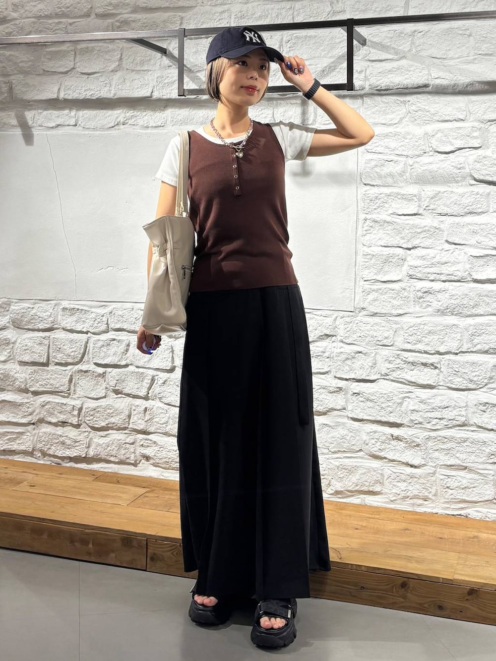 グレー系のサンダル、ブラウン系のタンクトップ、ホワイト系のTシャツ/カットソーを着用したレディースの夏コーディネートの2枚目の写真