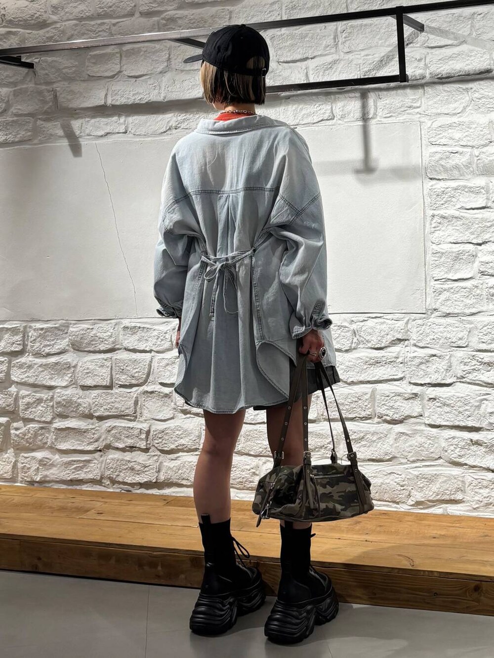 ブラック系のブーツ、ブルー系のシャツ/ブラウス、レッド系のTシャツ/カットソーを着用したレディースの春コーディネートの5枚目の写真