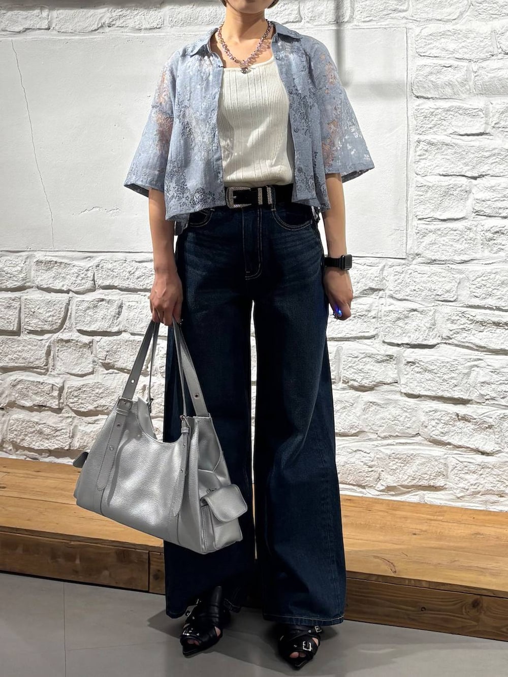 ブルー系のデニムパンツ、ホワイト系のタンクトップ、ブラック系のサンダルを着用したレディースの夏コーディネートの3枚目の写真