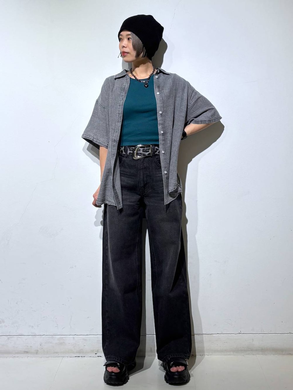ブラック系のデニムパンツ、ブラック系のシャツ/ブラウス、グリーン系のTシャツ/カットソーを着用したレディースの春コーディネートの2枚目の写真