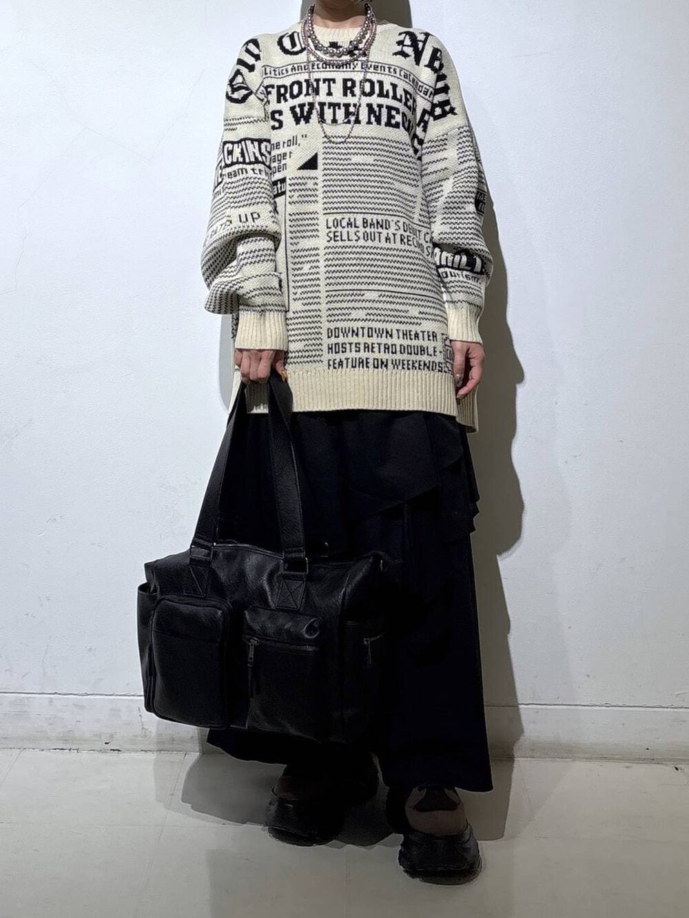 ブラウン系のブーツ、ブラック系のボストンバッグ、ブラック系のスカートを着用したレディースの冬コーディネートの2枚目の写真