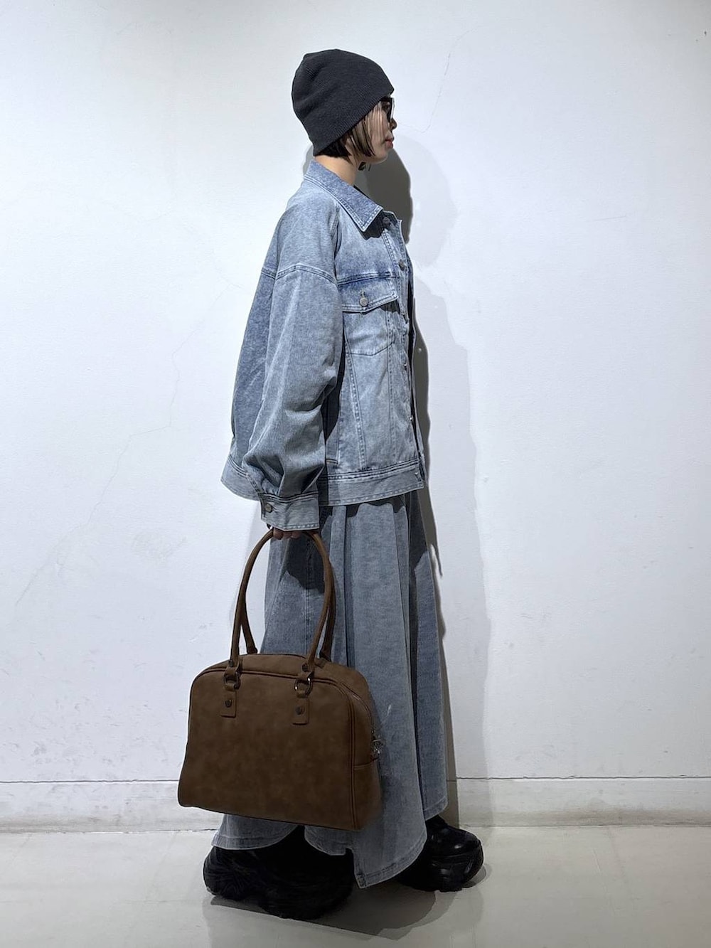 ブラック系のブーツ、ベージュ系のボストンバッグ、ホワイト系のTシャツ/カットソーを着用したレディースの春コーディネートの3枚目の写真