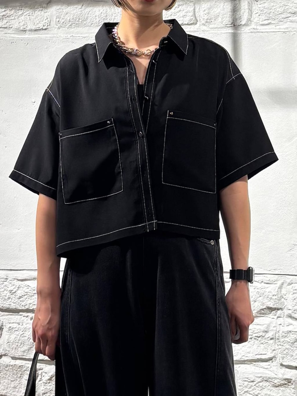 ブラック系のデニムパンツ、ブラック系のシャツ/ブラウス、ブラック系のキャミソールを着用したレディースの夏コーディネートの4枚目の写真