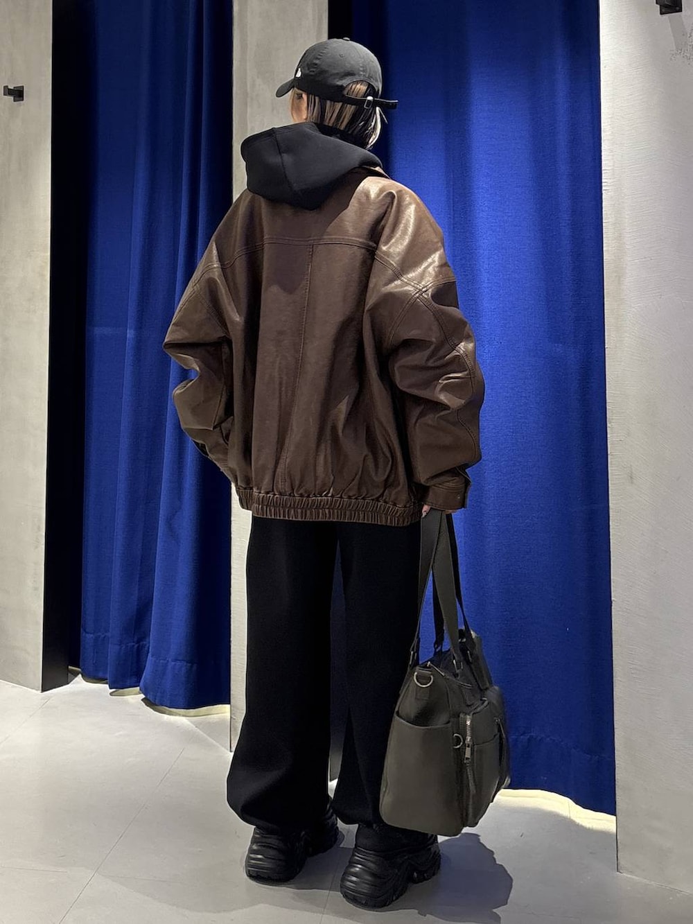 ブラック系のスニーカー、グリーン系のボストンバッグ、ブラック系のTシャツ/カットソーを着用したレディースの冬コーディネートの6枚目の写真