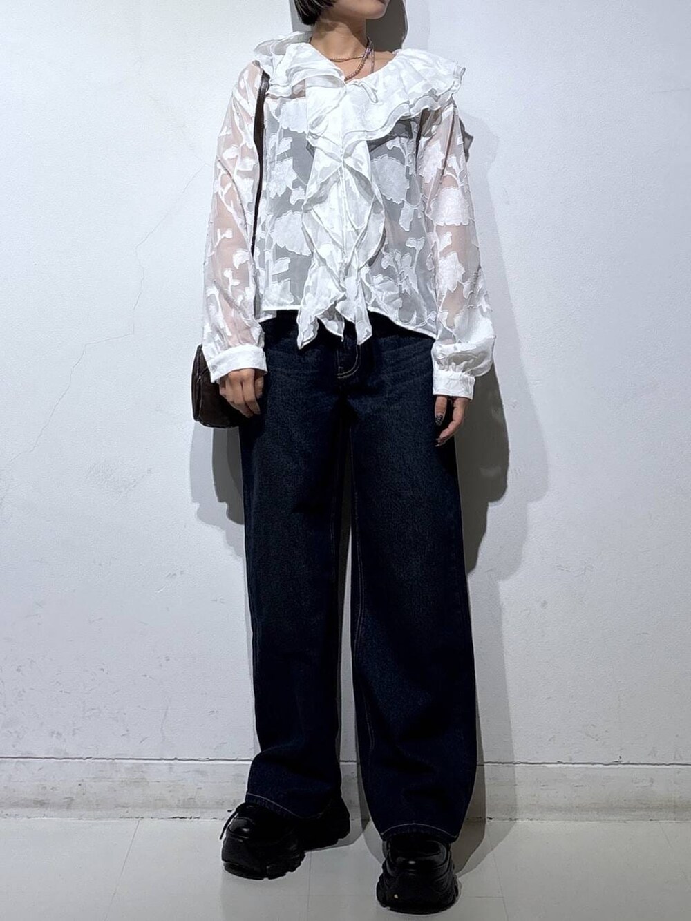 ブラック系のスニーカー、ブラック系のキャミソール、ブルー系のスラックスを着用したレディースの春コーディネートの3枚目の写真