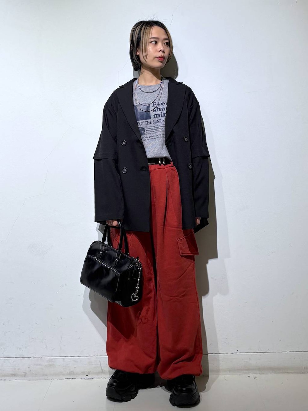 ブラック系のスニーカー、ブラック系のショルダーバッグ、ブラック系のテーラードジャケットを着用したレディースの春コーディネートの2枚目の写真