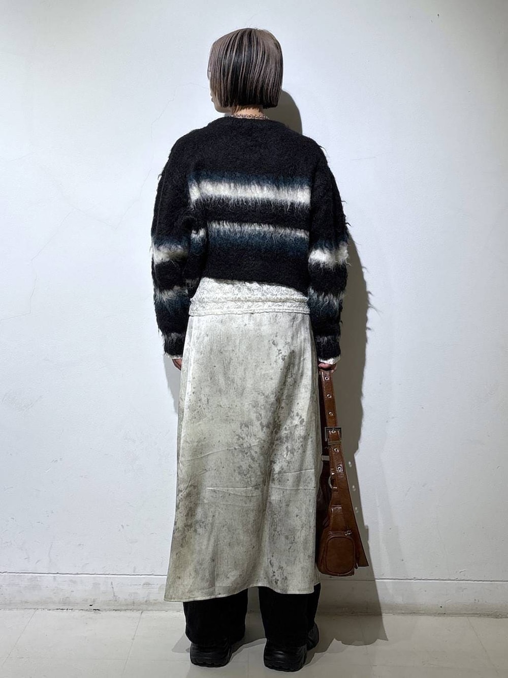 ブラック系のブーツ、ホワイト系のTシャツ/カットソー、ブラウン系のショルダーバッグを着用したレディースの冬コーディネートの4枚目の写真