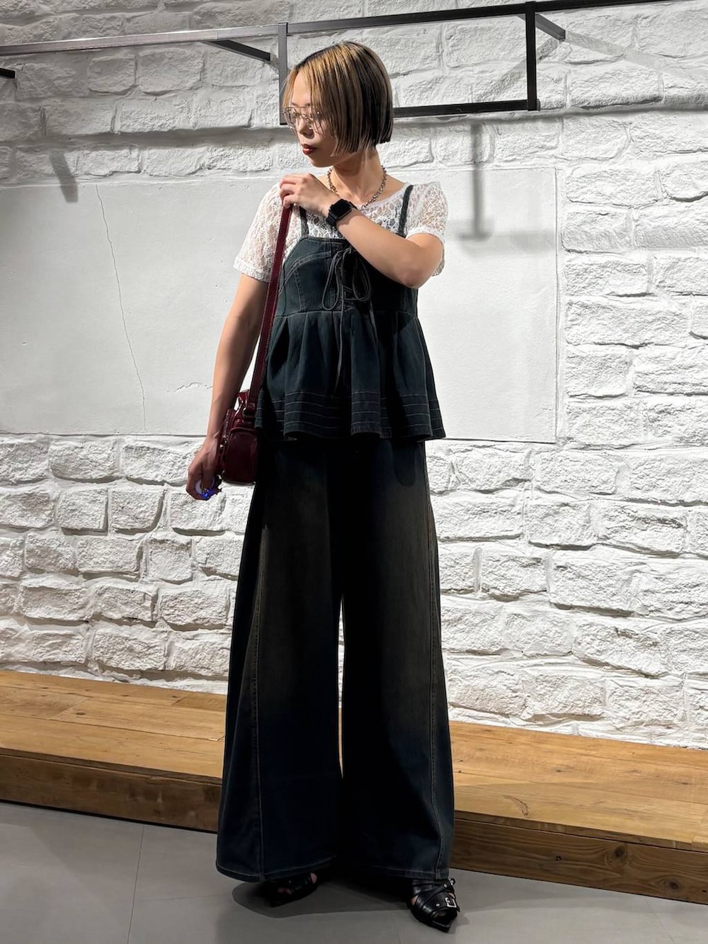 グリーン系のデニムパンツ、グリーン系のその他トップス、レッド系のショルダーバッグを着用したレディースの夏コーディネートの2枚目の写真
