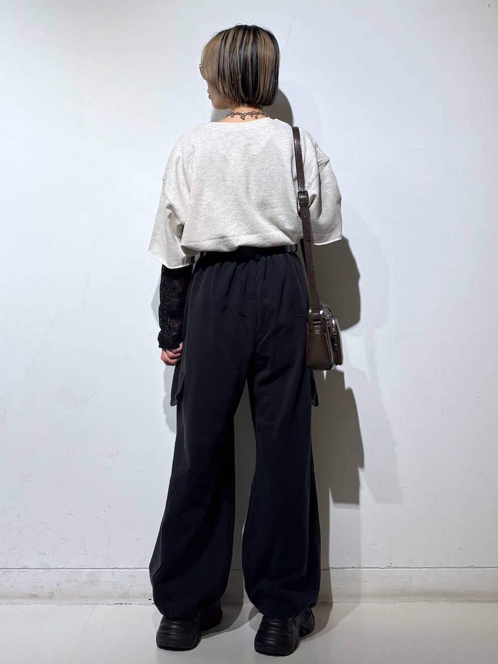 ブラック系のスニーカー、ブラウン系のショルダーバッグ、ブラック系のTシャツ/カットソーを着用したレディースの春コーディネートの5枚目の写真