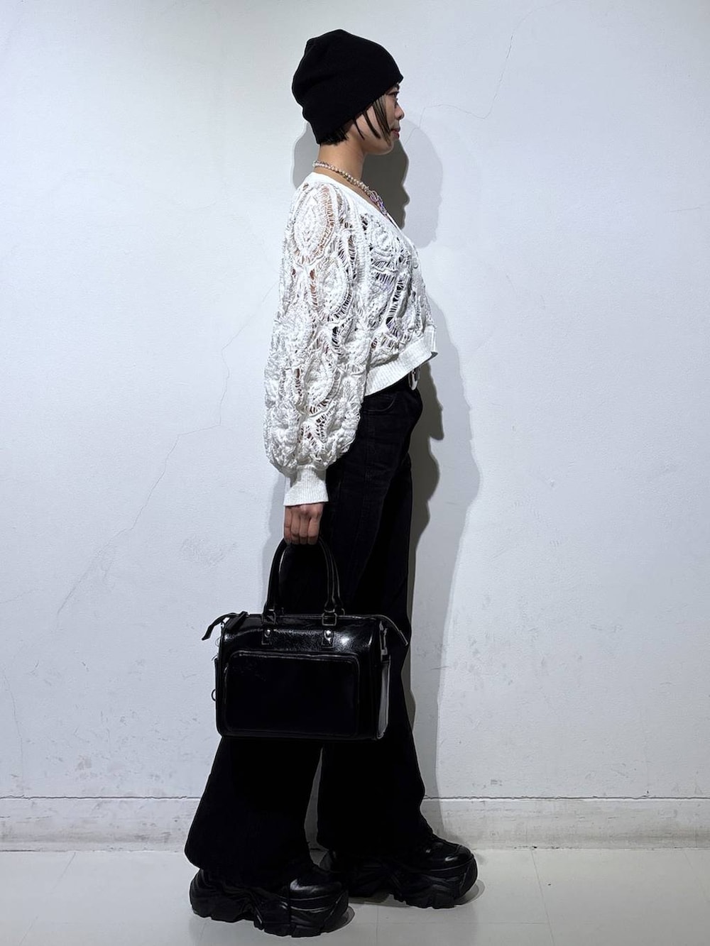 ブラック系のスニーカー、ブラック系のキャミソール、ホワイト系のカーディガン/ボレロを着用したレディースの春コーディネートの4枚目の写真