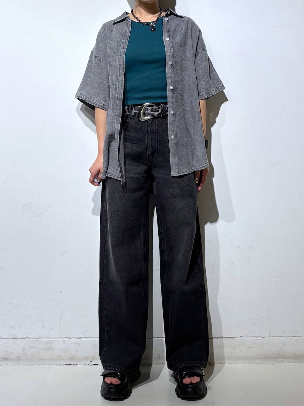 ブラック系のデニムパンツ、ブラック系のシャツ/ブラウス、グリーン系のTシャツ/カットソーを着用したレディースの春コーディネートの3枚目の写真
