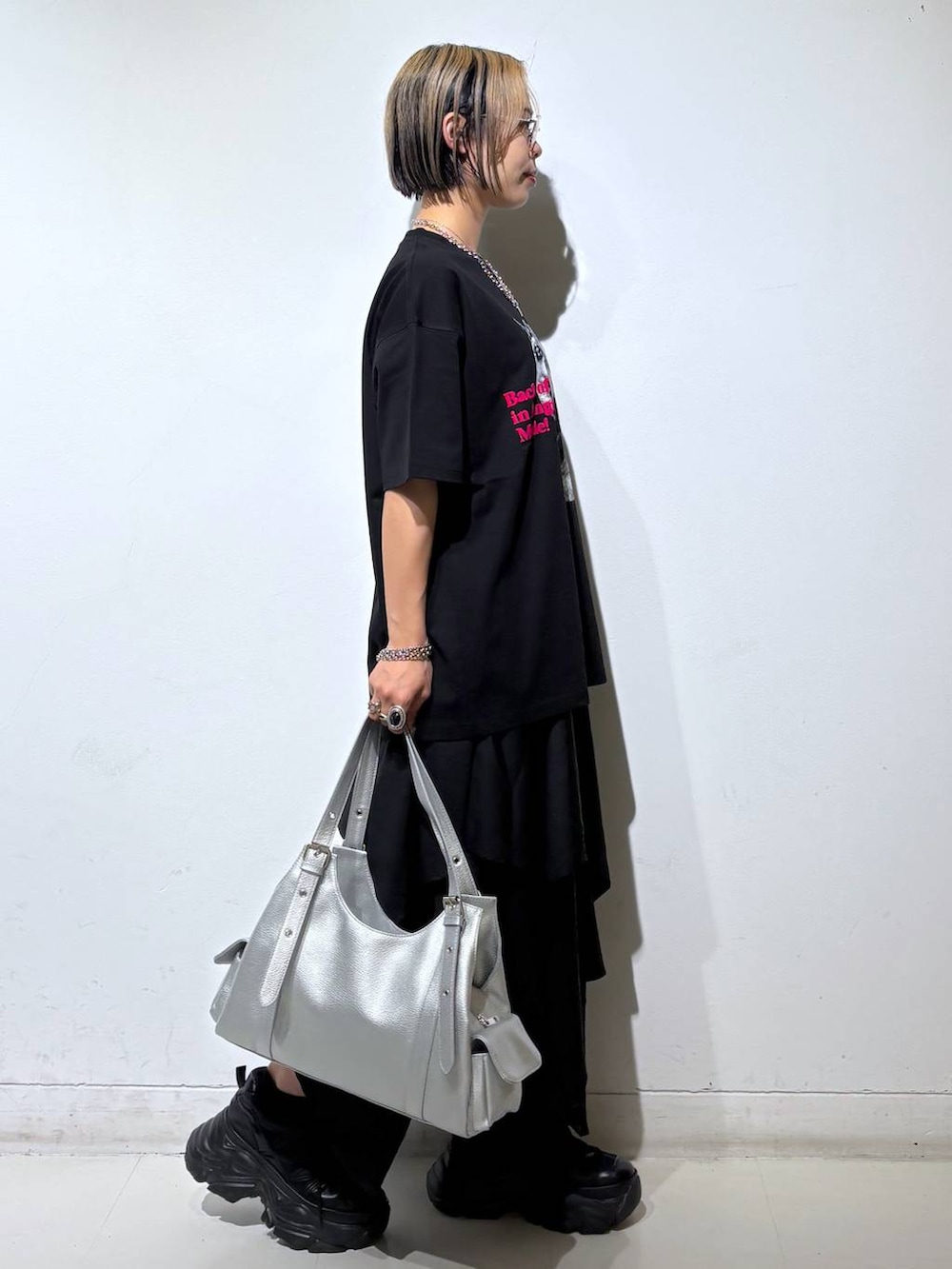 ブラック系のスニーカー、シルバー系のハンドバッグ、ブラック系のTシャツ/カットソーを着用したレディースの夏コーディネートの3枚目の写真