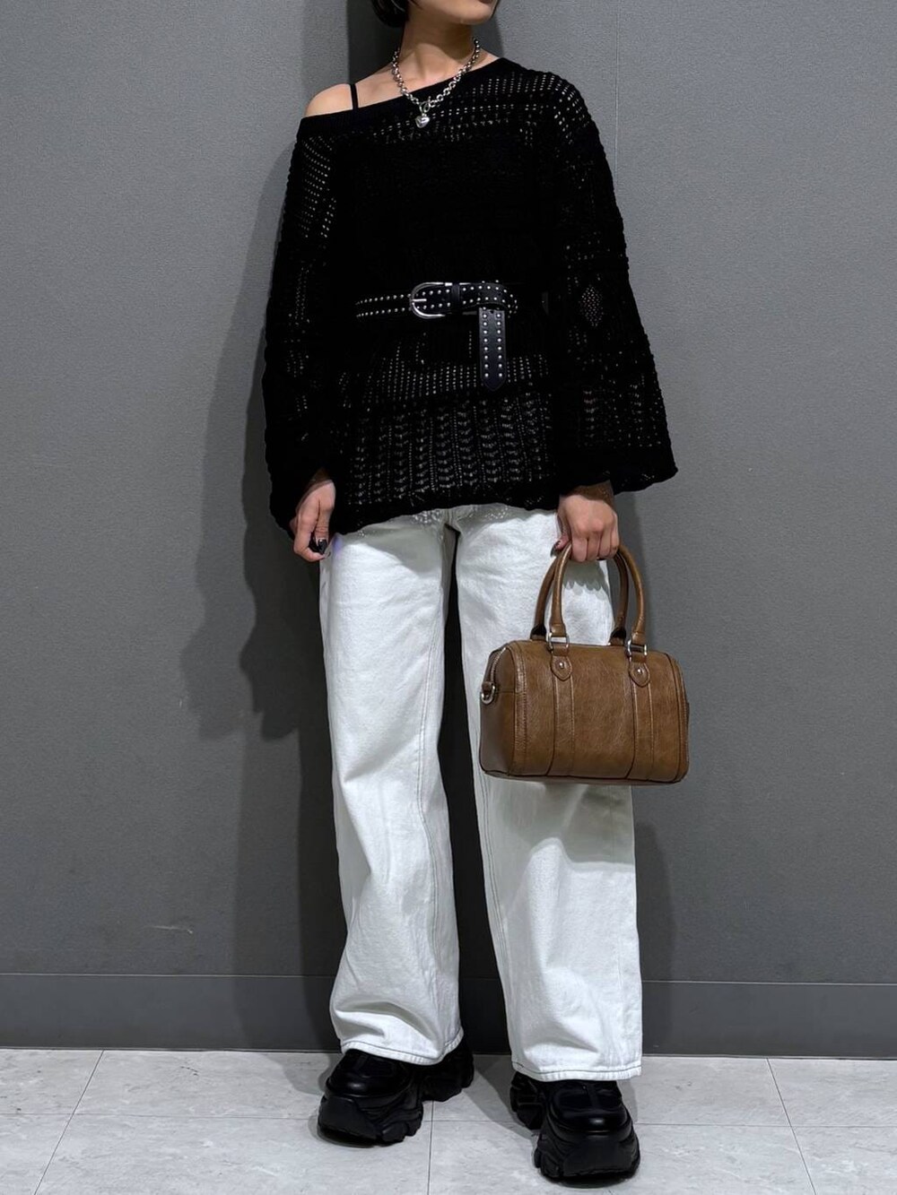 ブラック系のスニーカー、ブラック系のキャミソール、ホワイト系のスラックスを着用したレディースの春コーディネートの3枚目の写真