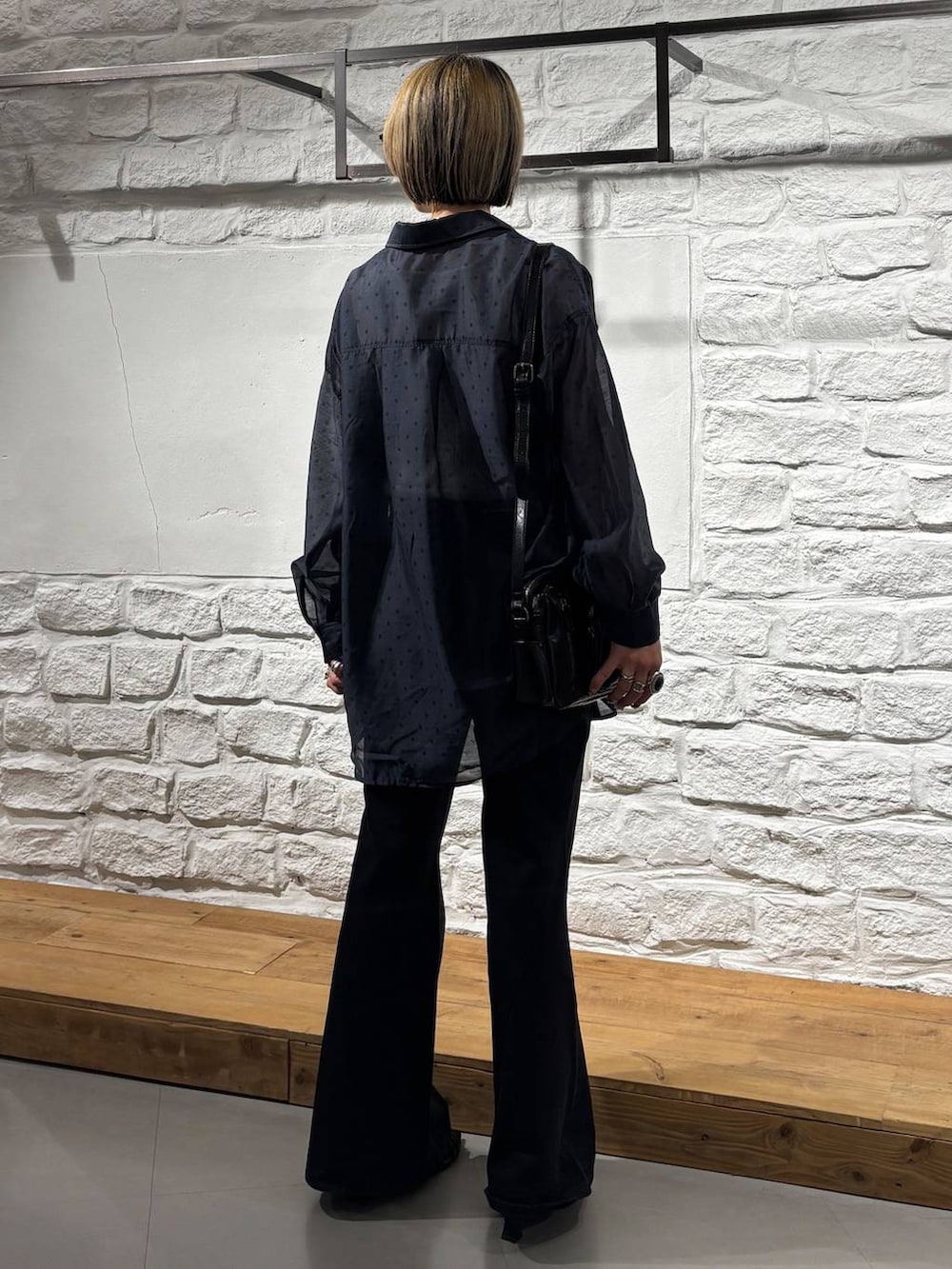 ブラック系のデニムパンツ、ホワイト系のタンクトップ、ブラック系のショルダーバッグを着用したレディースの夏コーディネートの5枚目の写真