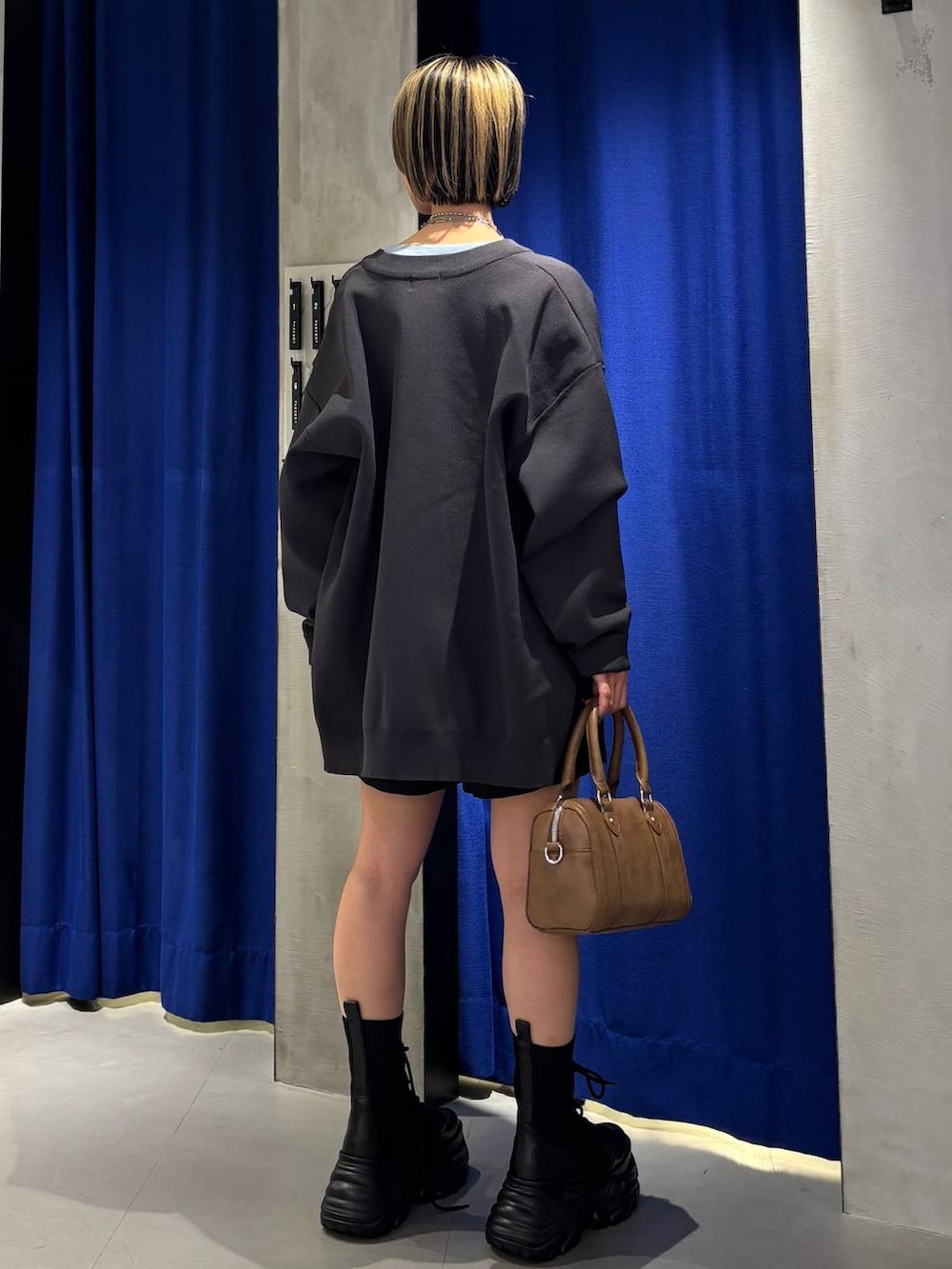 ブラック系のブーツ、ブラウン系のボストンバッグ、ブラック系のその他パンツを着用したレディースの春コーディネートの5枚目の写真