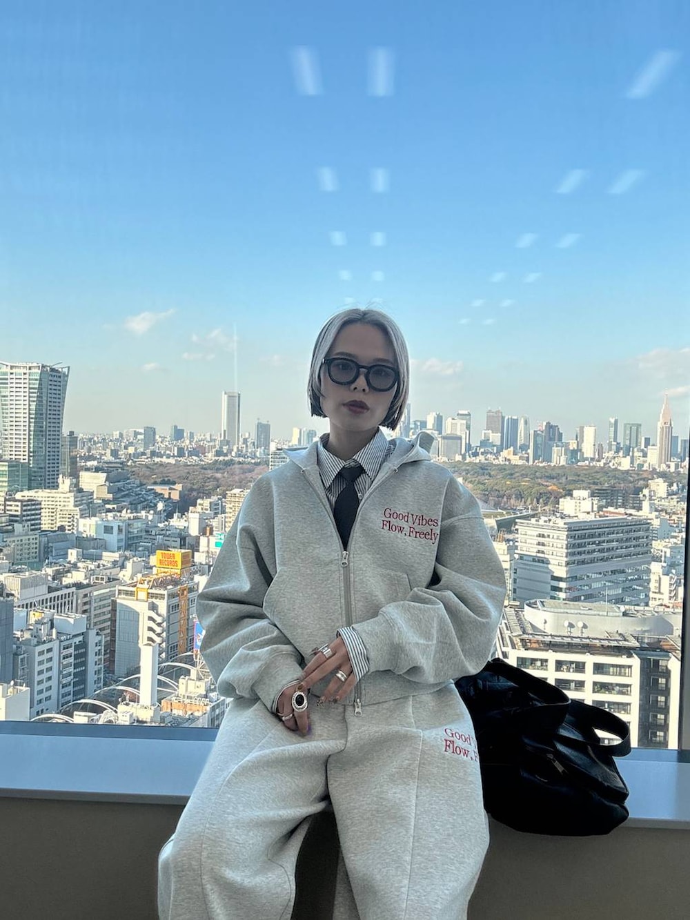 ブラック系のスニーカー、ブラック系のボストンバッグ、グレー系のパーカーを着用したレディースの冬コーディネートの3枚目の写真