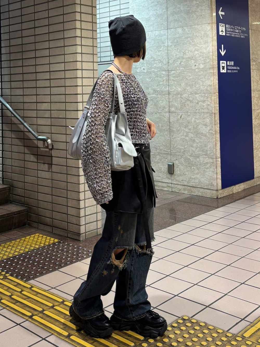 ブラック系のスニーカー、ブラック系のニット/セーター、シルバー系のハンドバッグを着用したレディースの春コーディネートの5枚目の写真