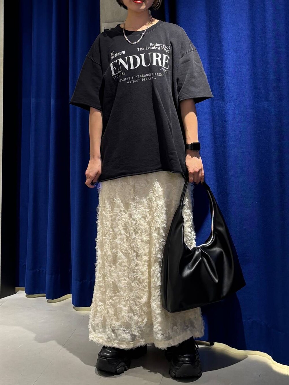ブラック系のスニーカー、ブラック系のトートバッグ、ブラック系のTシャツ/カットソーを着用したレディースの春コーディネートの3枚目の写真