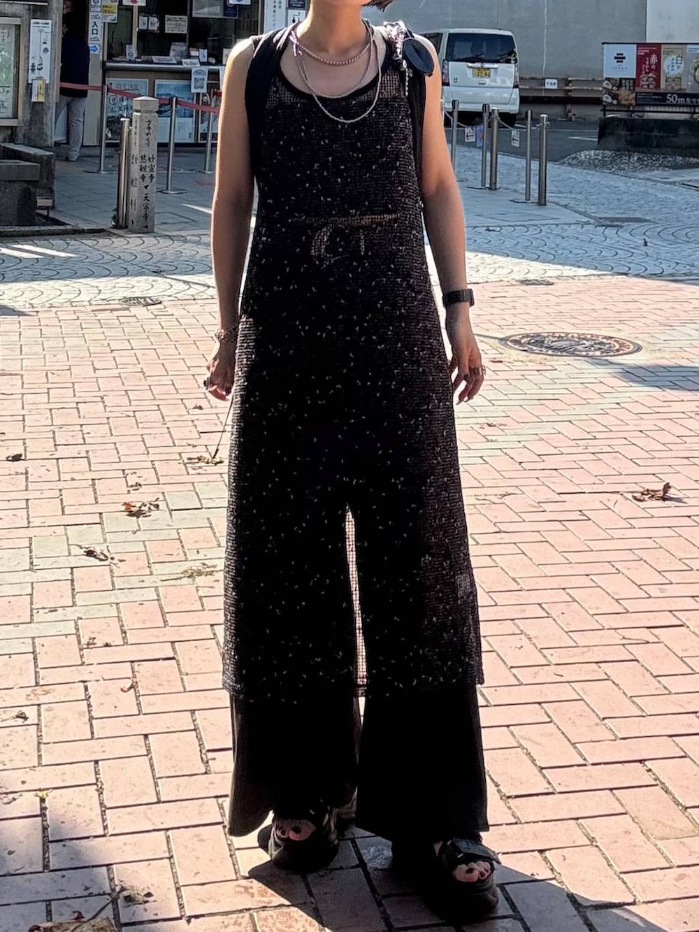 ブラウン系のデニムパンツ、ブラック系のサンダル、ブラック系のワンピースを着用したレディースの夏コーディネートの2枚目の写真