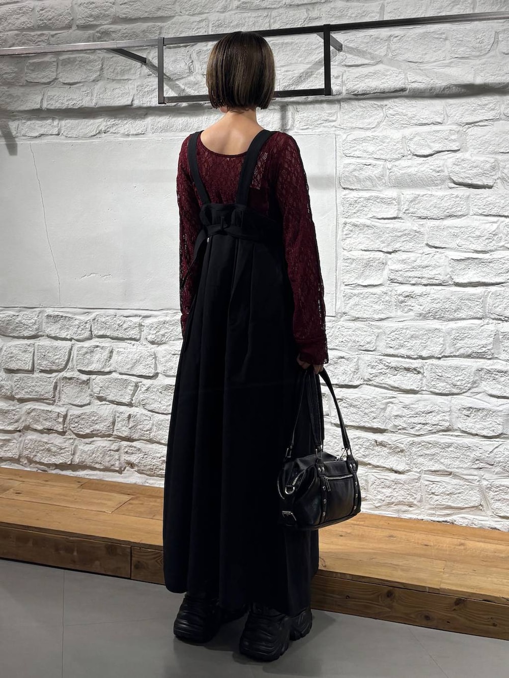 ブラック系のショルダーバッグ、ブラック系のジャンパースカート、ブラック系のスニーカーを着用したレディースの夏コーディネートの6枚目の写真