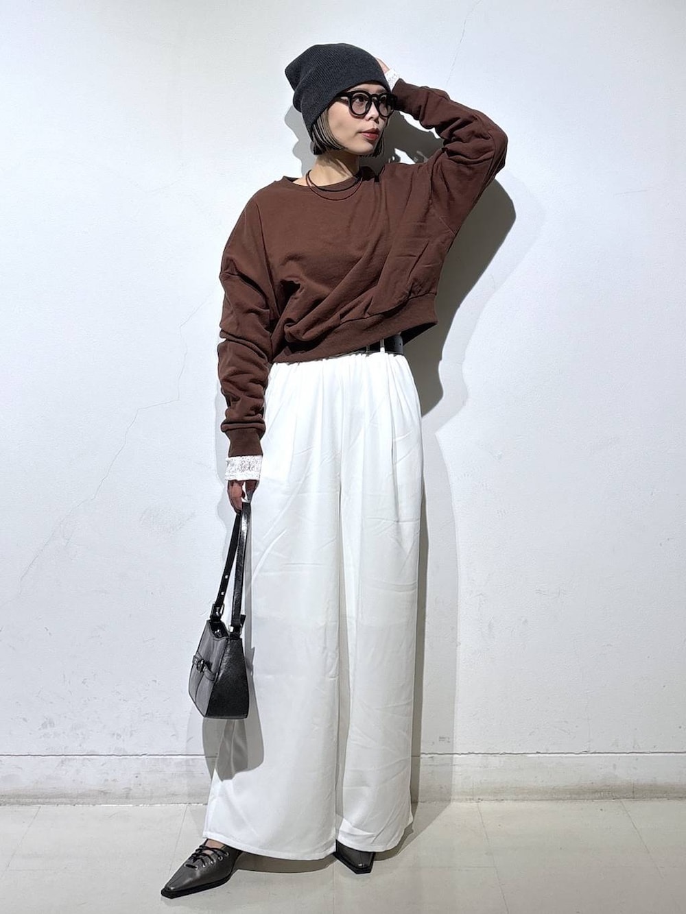 ブラウン系のスウェット、ブラック系のハンドバッグ、ブラック系のサンダルを着用したレディースの春コーディネートの3枚目の写真