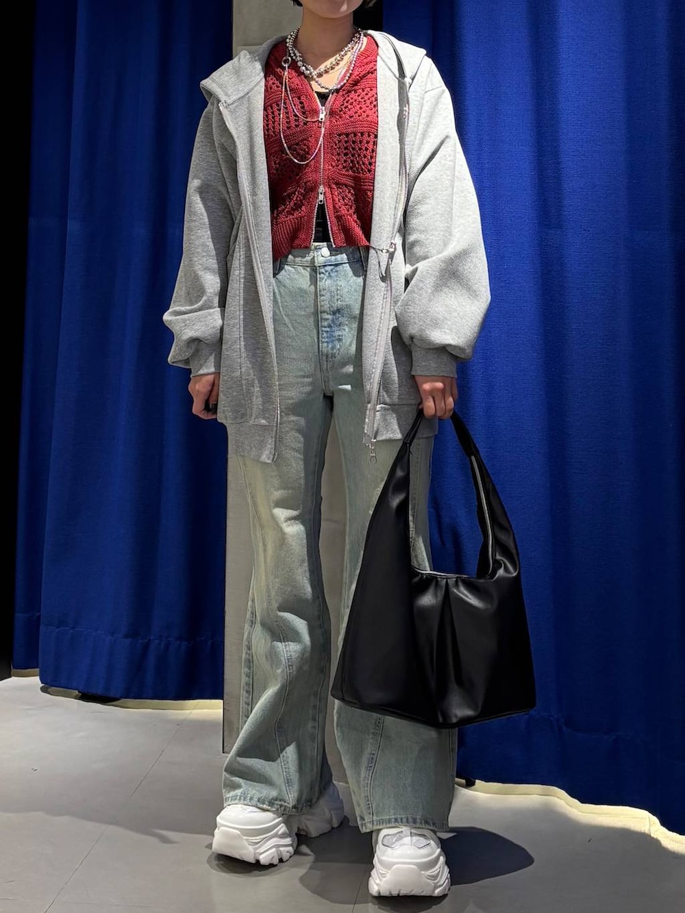 ホワイト系のスニーカー、ブラック系のキャミソール、ブルー系のデニムパンツを着用したレディースの春コーディネートの2枚目の写真