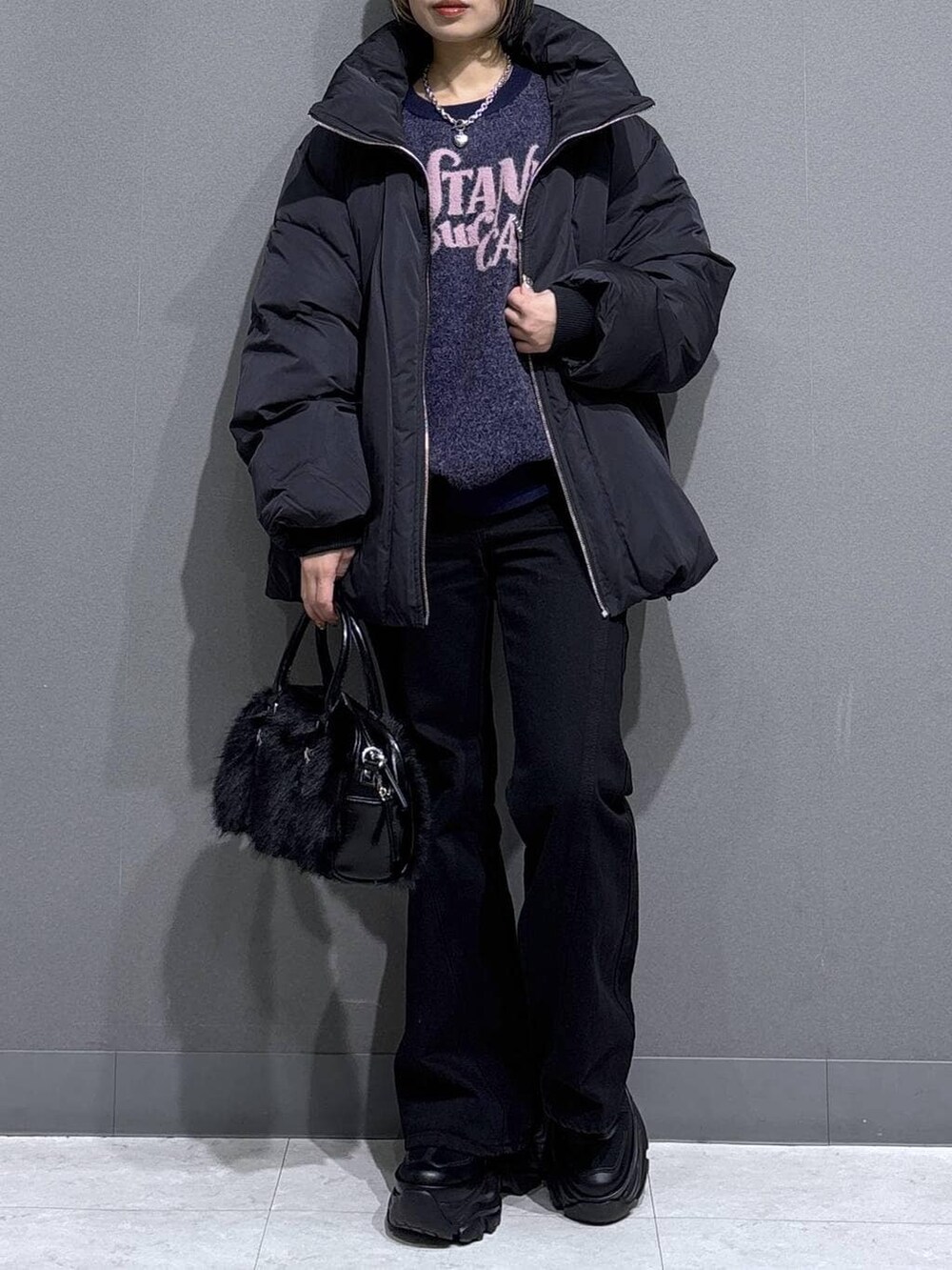 ブラック系のブーツ、ブラック系のデニムパンツ、ブラック系のブルゾンを着用したレディースの冬コーディネートの2枚目の写真