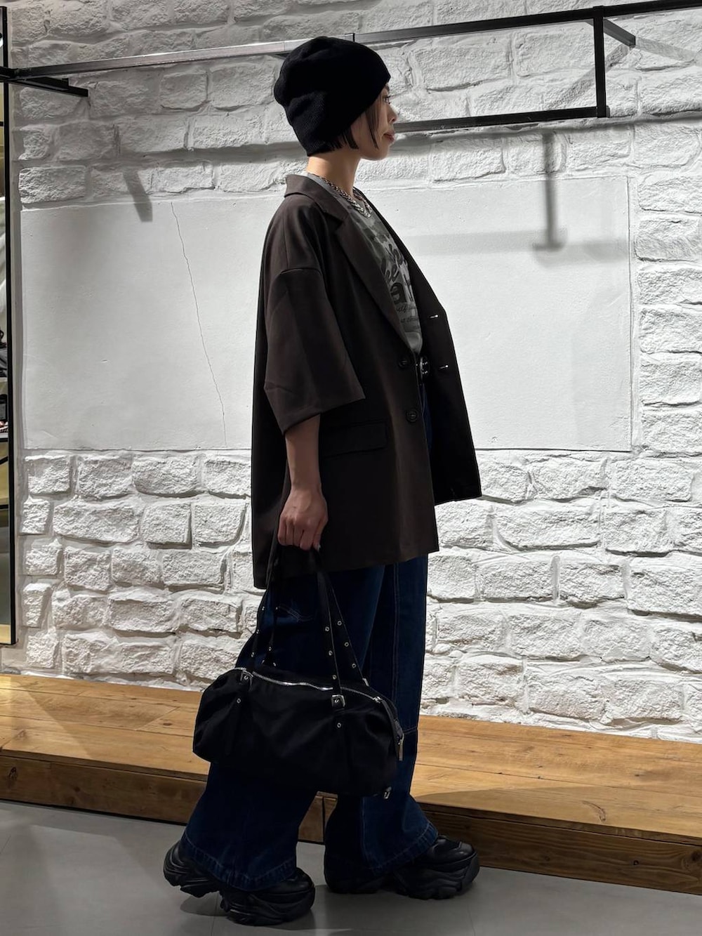 ブラック系のスニーカー、ブルー系のデニムパンツ、その他のTシャツ/カットソーを着用したレディースの春コーディネートの4枚目の写真
