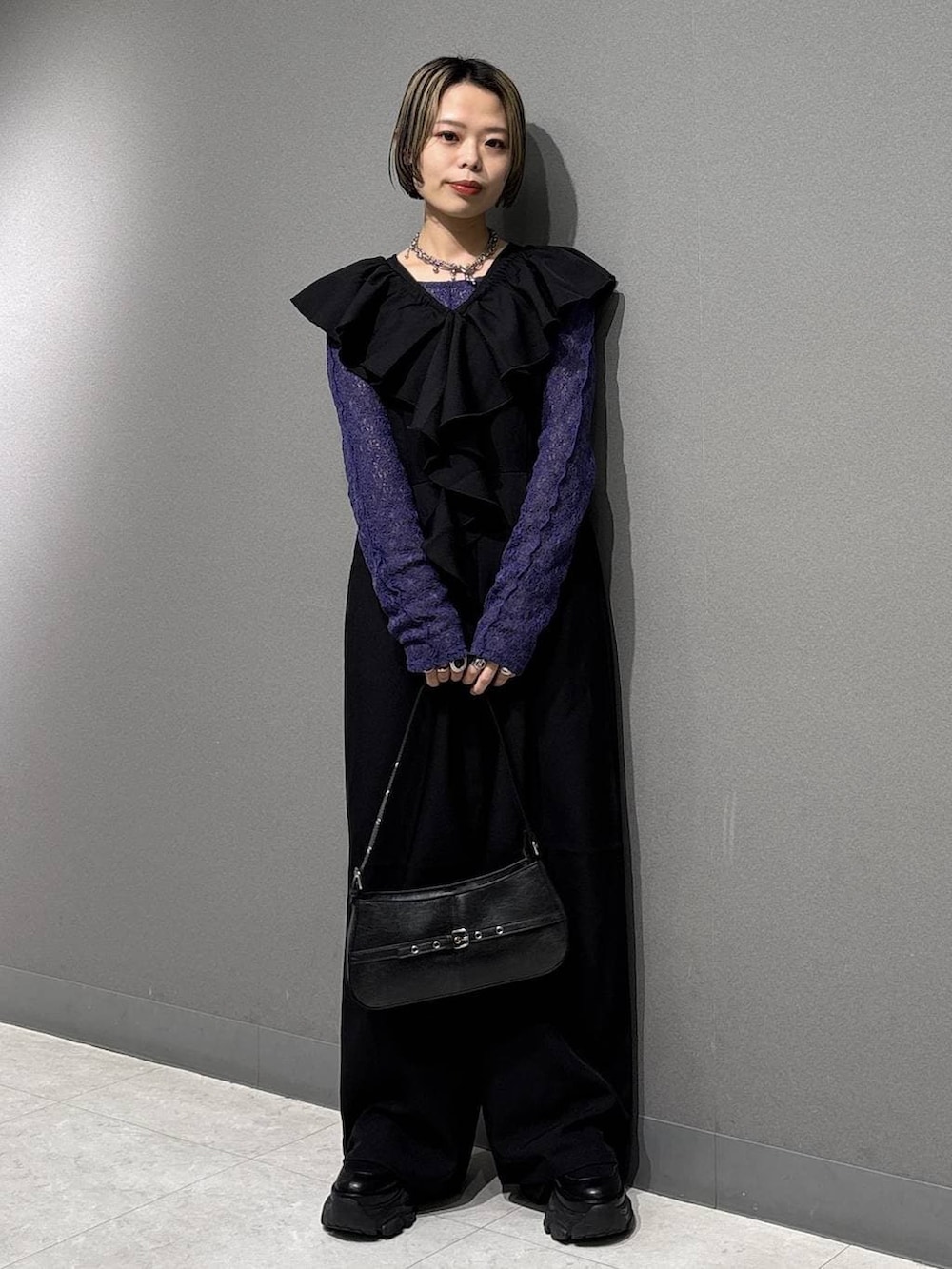 ブラック系のブーツ、ブラック系のハンドバッグ、ブルー系のTシャツ/カットソーを着用したレディースの春コーディネートの2枚目の写真