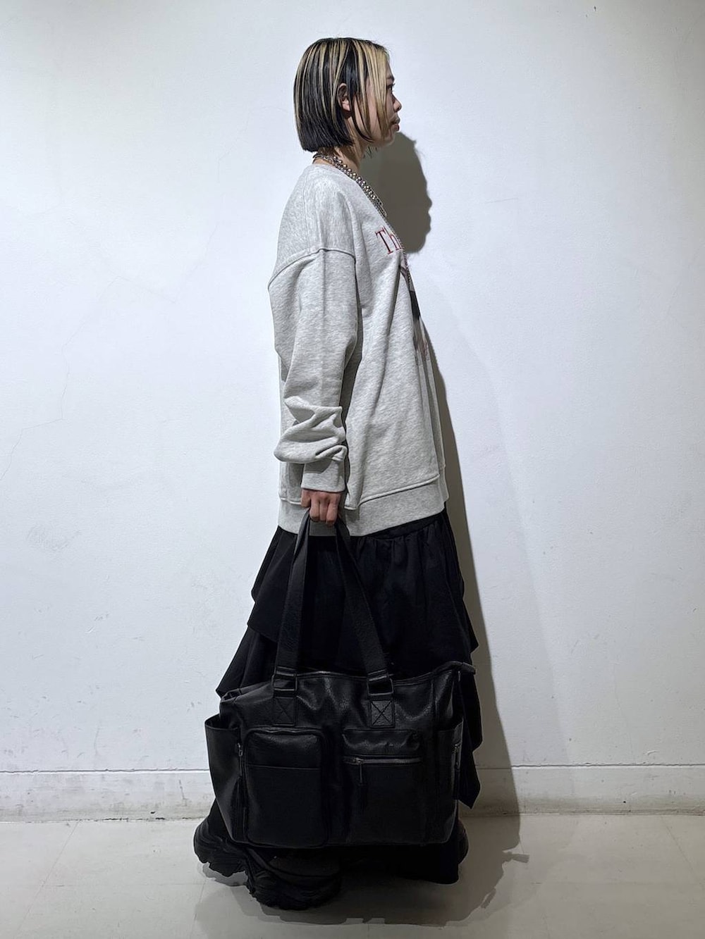 ブラウン系のブーツ、ブラック系のボストンバッグ、ブラック系のスカートを着用したレディースの冬コーディネートの3枚目の写真