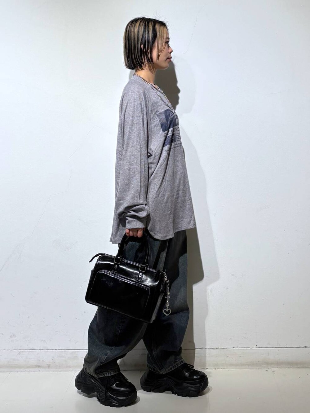 ブラック系のスニーカー、ブルー系のデニムパンツ、ブラック系のショルダーバッグを着用したレディースの春コーディネートの4枚目の写真