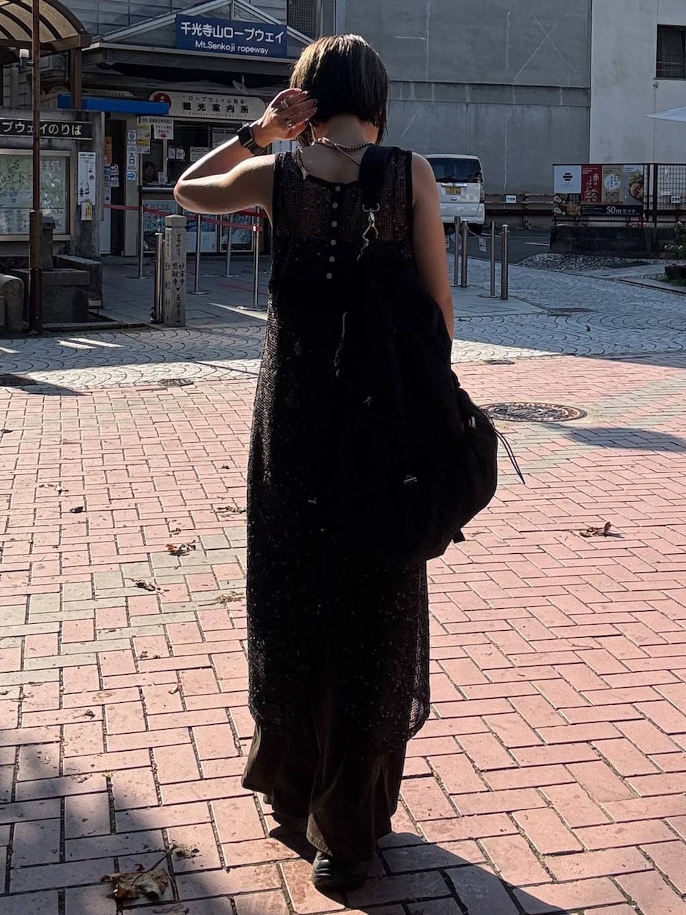 ブラウン系のデニムパンツ、ブラック系のサンダル、ブラック系のワンピースを着用したレディースの夏コーディネートの4枚目の写真