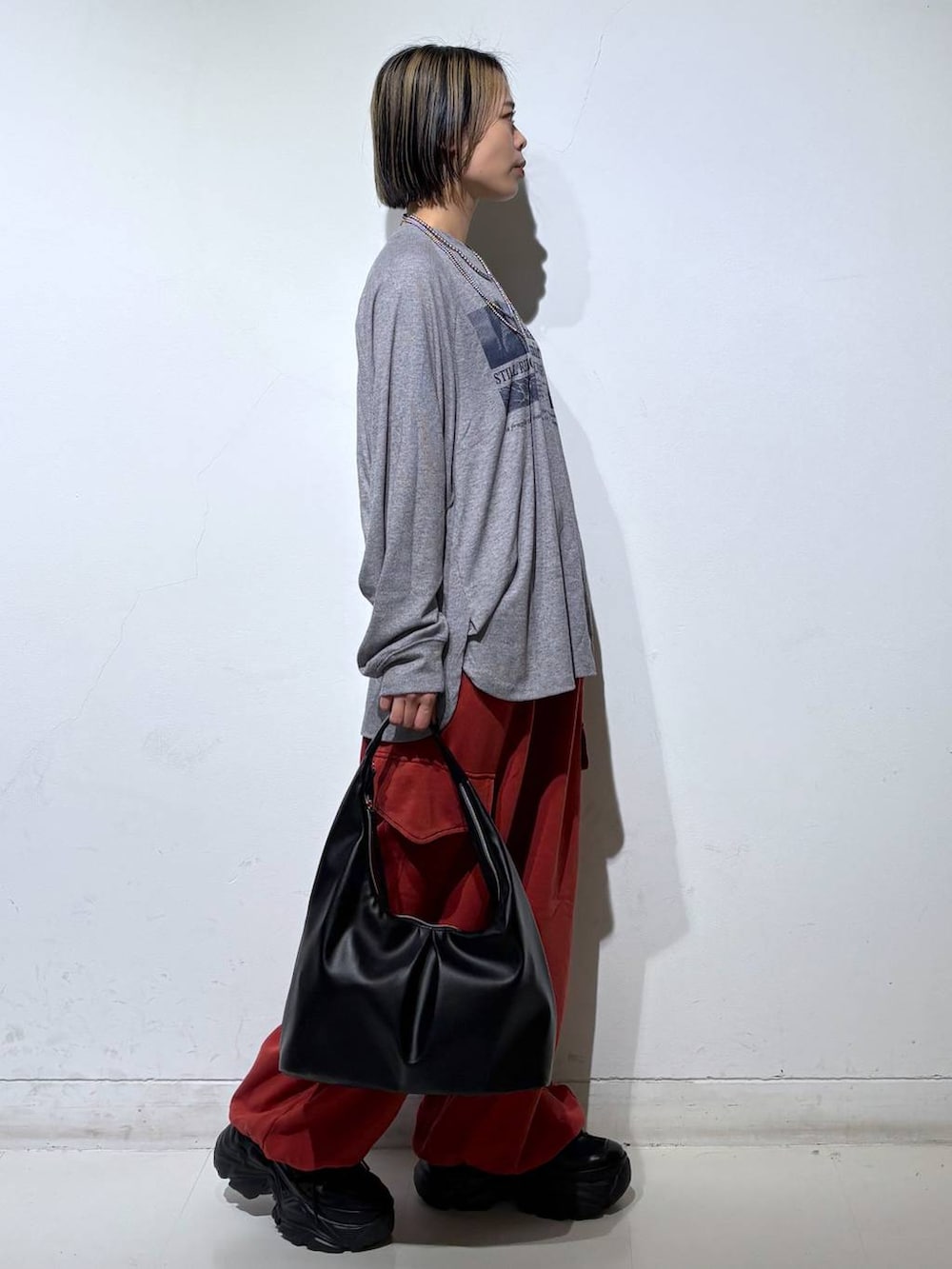 ブラック系のスニーカー、ブラック系のトートバッグ、グレー系のTシャツ/カットソーを着用したレディースの春コーディネートの4枚目の写真