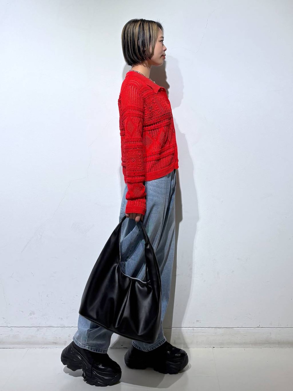 ブラック系のスニーカー、ブラック系のキャミソール、ブルー系のデニムパンツを着用したレディースの春コーディネートの4枚目の写真