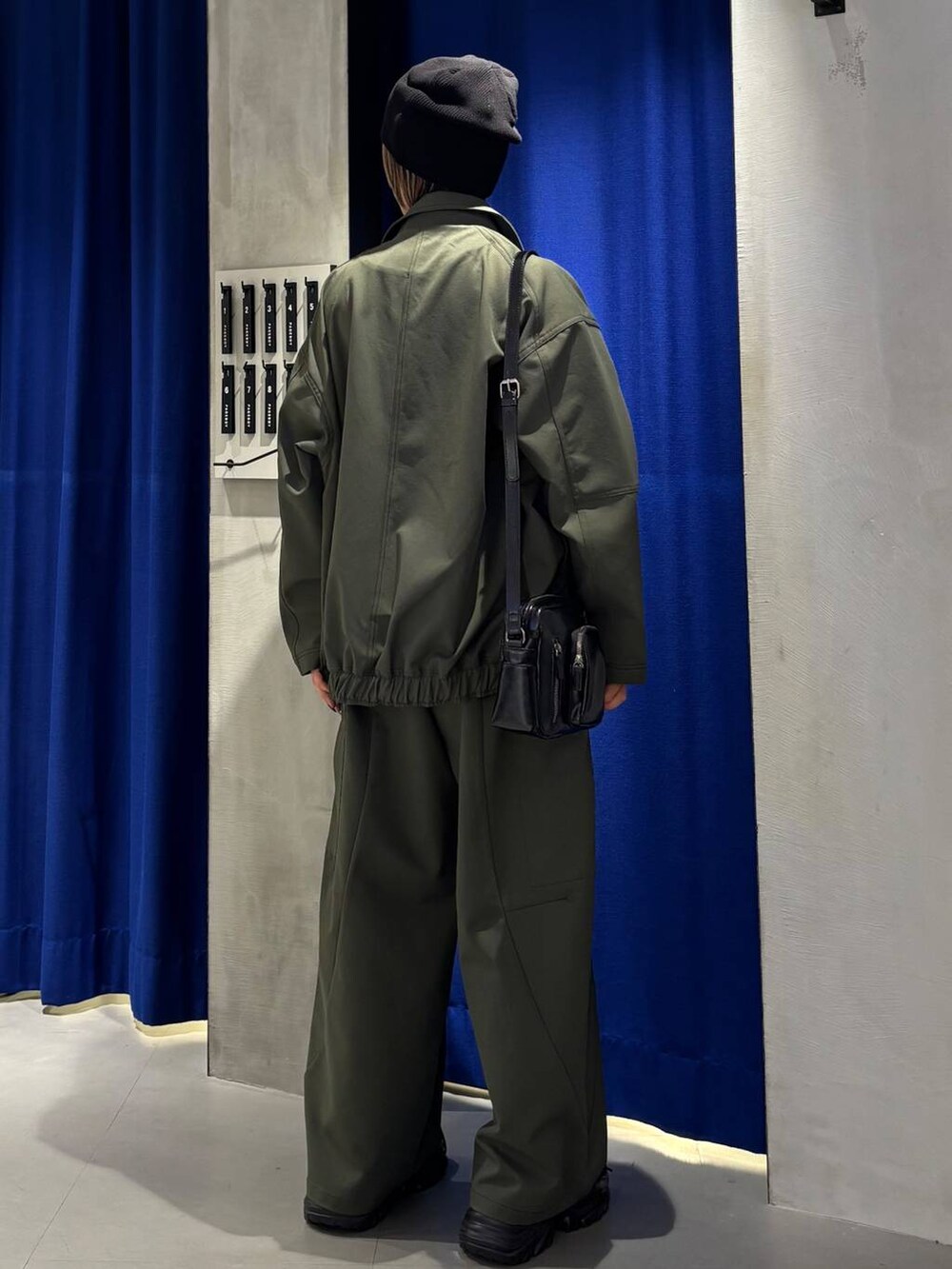 ブラック系のスニーカー、ブラック系のタンクトップ、グリーン系のカーゴパンツを着用したレディースの春コーディネートの6枚目の写真